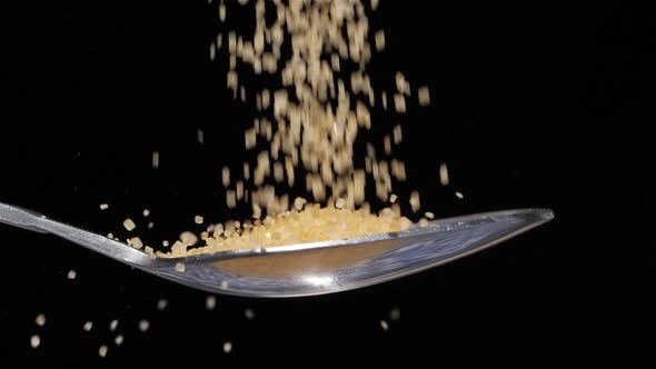 Brown Cane Sugar Dropped On Spoon