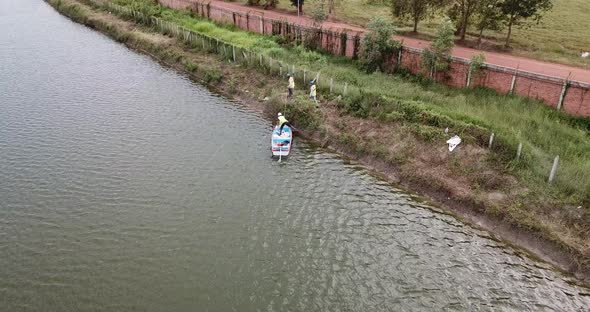 Aerial shot of man in boat on river driving at sea shore on beautiful day outdoor in nature