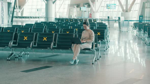 Empty Airport Hall with a Woman Working on Her Laptop