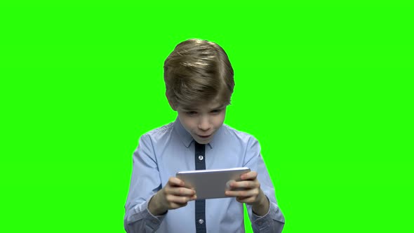 Portrait of a Cute Little Kid Playing Games on Smartphone