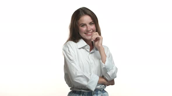 Studio Shot of Attractive Caucasian Woman in Office Clothing Smiling Silly and Coquettish Touching