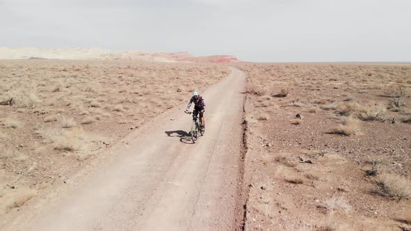 Drone Shot of Bicyclist Ride in Canyon Desert Mountains in Kazakhstan