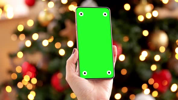 Woman with Green Screen on Smartphone on Christmas