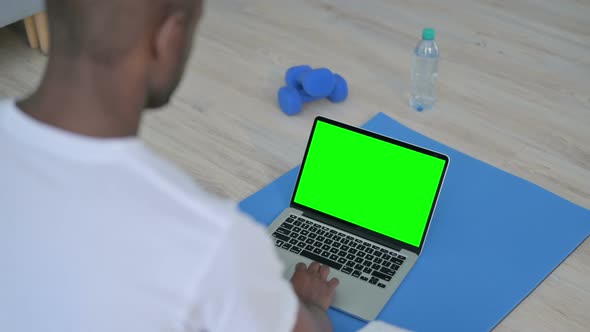 African Man Using Laptop with Chroma Key Screen on Yoga Mat