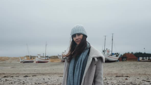 Portrait of Beautiful Happy Female Tourist Smiling at Camera with Bird Feather at Cold Baltic Sea