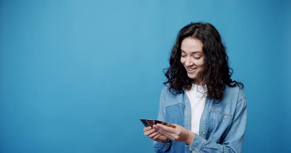 A Girl Receives a Credit Card and She is Happy Isolated on Background Studio