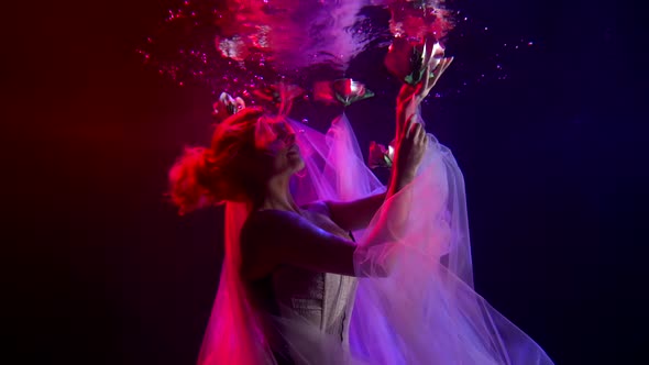 A Beautiful Girl Is Under Water, Her Train of Dress Is Wrapped Around Her Along with Flower Buds