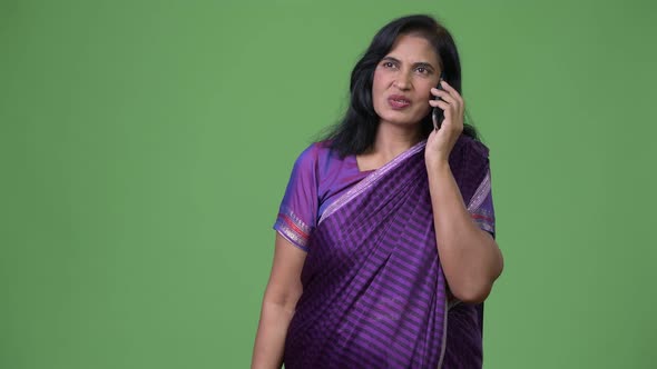 Mature Beautiful Indian Woman Talking on the Phone While Thinking