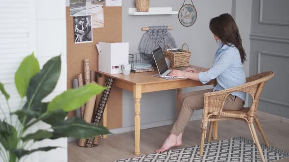 Designer Works in a Home Studio. Young Woman in Casual Wear Is Using a Laptop