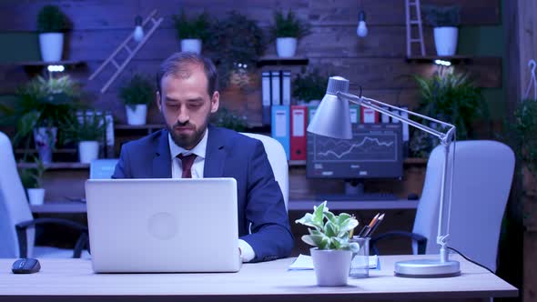 In Modern Loft Type Office Businessman Works Late at Night