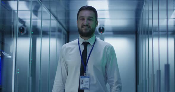 Smiling Engineer in Corridor of Data Center