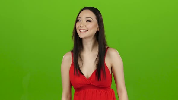 Girl of Asian Appearance Has Fun and Makes Different Grimaces. Green Screen