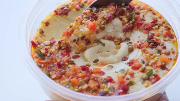 Hummus with spices in a bowl with a spoon. Vegan food concept.