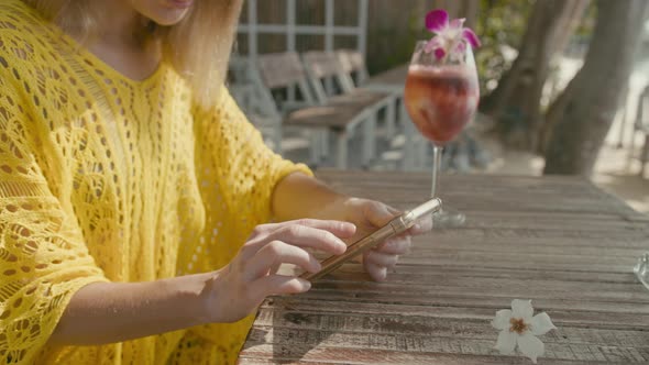 A Pretty Young Woman with Vitiligo Pigmentation Sits By the Beach Chatting on the Phone