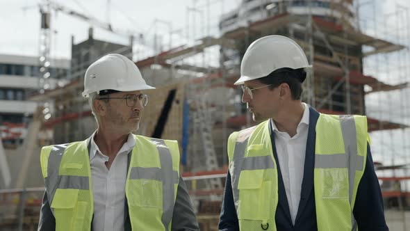 Engineers in Helmet Talking and Walking on Construction Site