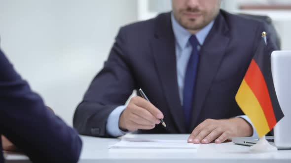 German Boss Signing Employment Contract With Immigrant Employee, Shaking Hand