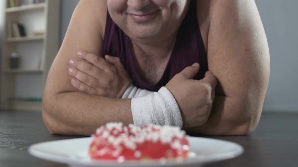 Smiling Plump Man Lying on The Floor and Looking at Donut with Love, Dieting