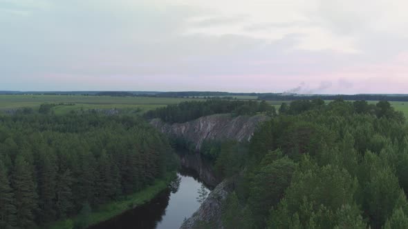 Aerial View of the River with a Rock and Forest on the Banks