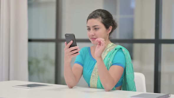 Attractive Indian Woman Using Smartphone in Office