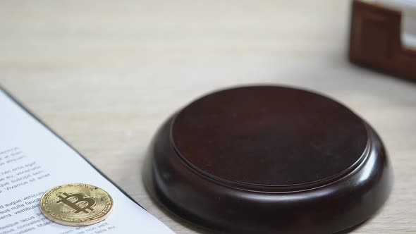 Bitcoin on Table, Judge Hitting Gavel Once, Cybercrime Problem, Stealing Money