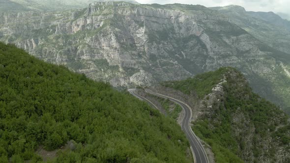 Flying Towards Canyon Valley Revealing Winding Road with 180 Turn