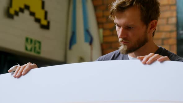 Man examining a surfboard