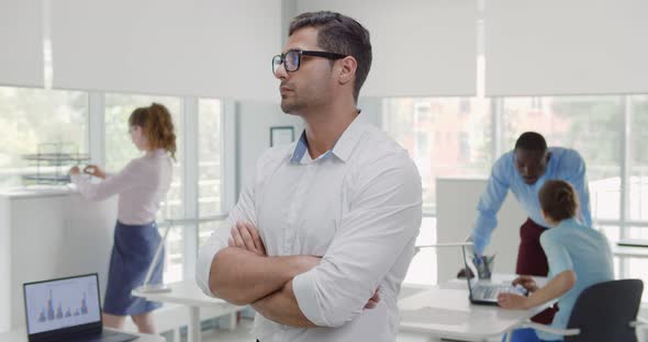 Medium Shot of Indian Businessman with Arms Crossed Looking at Camera in Office