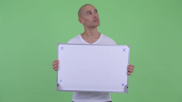 Happy Handsome Bald Man Thinking While Holding White Board