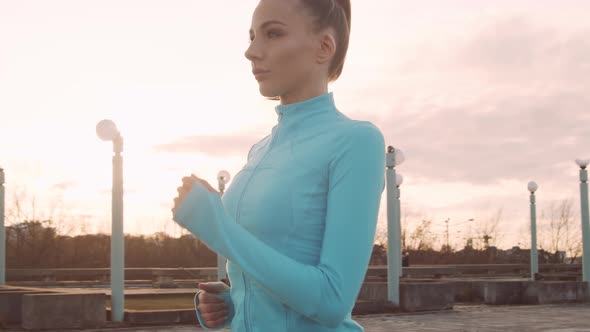 Young, beautiful and sporty woman having evening training outdoor.