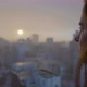 Woman looks out at urban city in the distance as day turns to night or in dawn. Golden Hour Sunset - VideoHive Item for Sale
