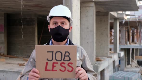 Construction Worker Stands with Placard Jobless Opposite Construction Site