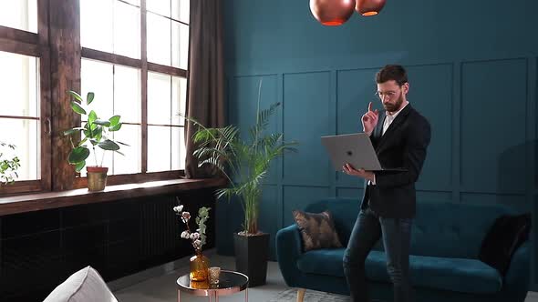 Portrait of an Elegant Businessman with Laptop at the Luxury Blue Office Interior.