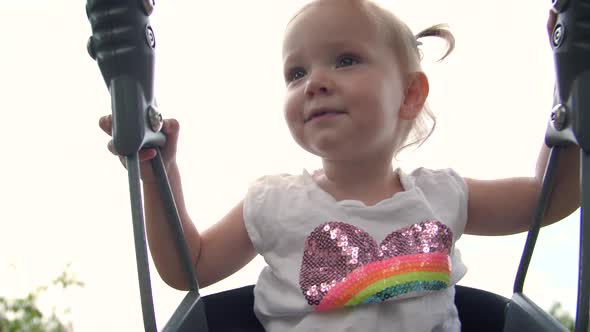 Cute Toddler Girl In Playground Swing Slow Motion