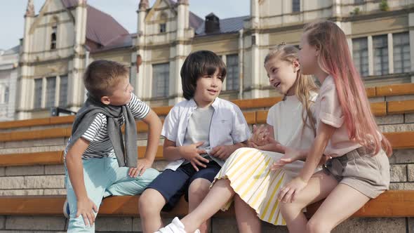 Four Children Sitting Together Smiling and Talking.