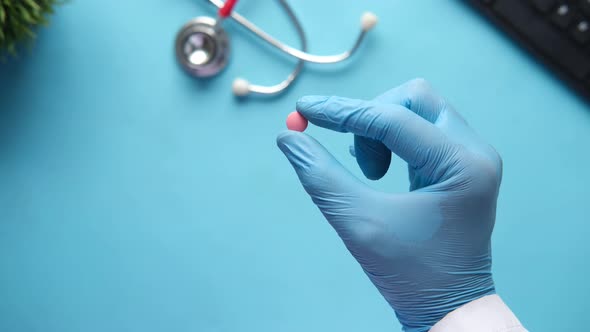 Doctor Holding Medical Pill on Palm of Hand