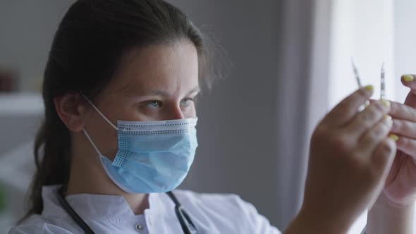 Headshot Portrait Serious Focused Nurse in Coronavirus Face Mask Examining Drug Ampoules Indoors