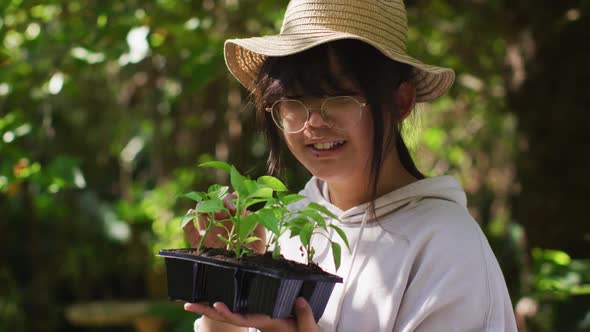 Asian girl gardening and smiling on sunny day