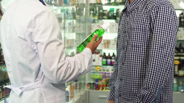 Doctor Giving Bottle of Mouth-wash To Patient and Shaking Hands