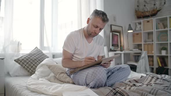 Man Drawing in the Bedroom