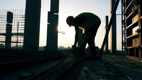 A Builder Uses Disk Saw While Working at a Construction Site alt