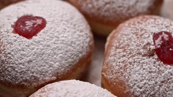Hanukkah jelly doughnuts covered with powdered sugar, slow motion