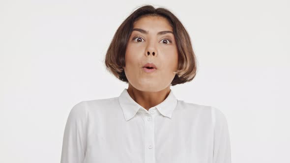 Young Beautiful Brunette East Asian Female in Shirt Screaming Wow in Surprise on White Background