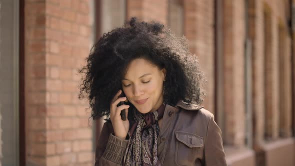 Portrait of Young African American Woman Talking on Her Smartphone