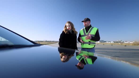 Portrait of Professional Driving Instructor Talking with Beautiful Woman Outdoors on Sunny Autumn