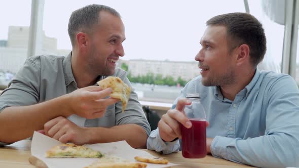 Two Friends Eat Pizza and Talk in a Cafe