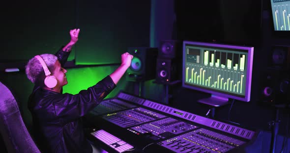 Musician and sound female engineer mixing new album inside boutique recording studio