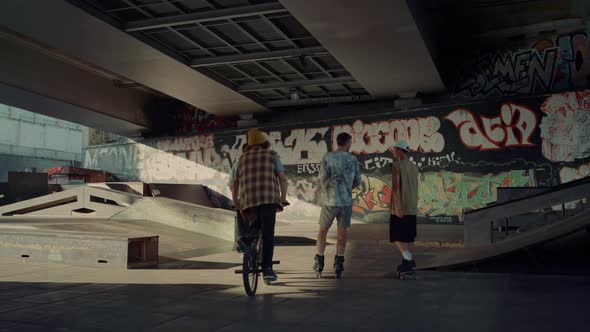 Young Riders Talking Together at Skate Park Graffiti