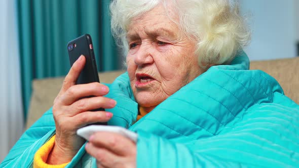 Old Woman Wrapped on Blue Blanked at Home Calling to Doctor By Phone