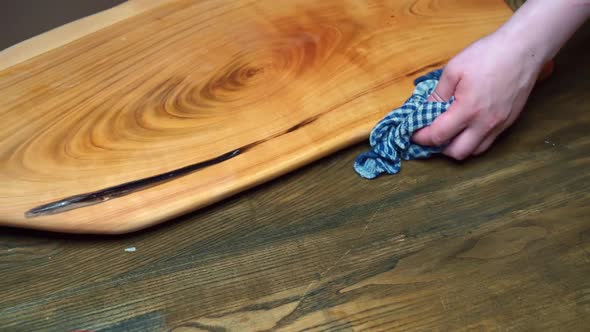 the Man's Hand Wipes the Table and Cutting Board with a Rag