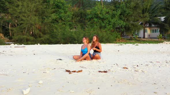 Beautiful Fun Women on Holiday Enjoying Life at The Beach on Summer White Sandy and Blue